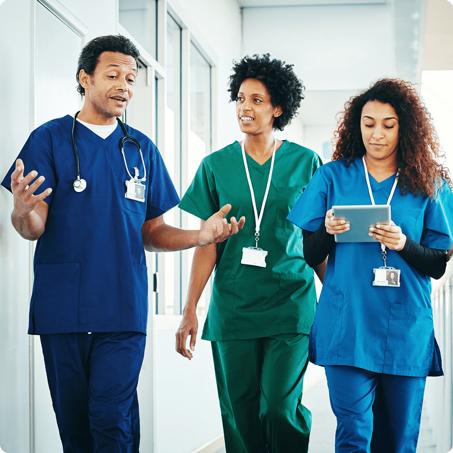 Healthcare professionals walking and discussing in hallway.